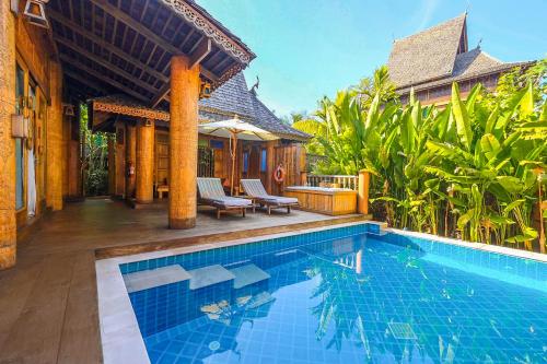 a swimming pool in front of a villa at Santhiya Phuket Natai Resort & Spa in Natai Beach