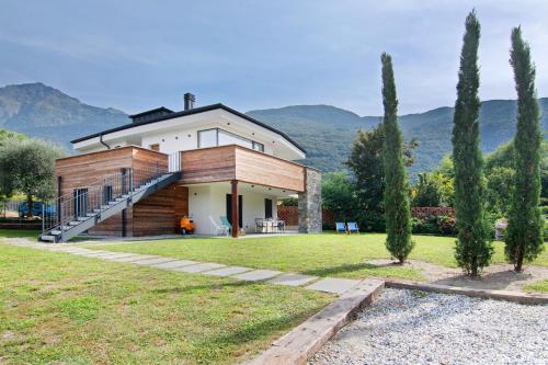 a house with a large yard with two trees at La villa del lago in terrazzo in Colico