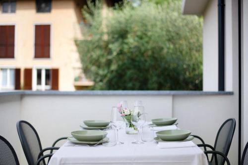 a table with a white table cloth and bowls and chairs at La villa del lago in terrazzo in Colico