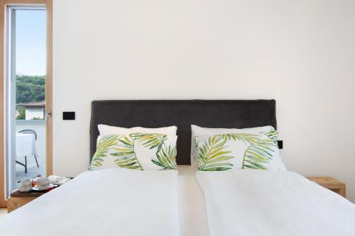 a bedroom with a bed with white sheets and pillows at La villa del lago in terrazzo in Colico