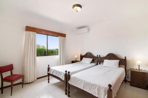a bedroom with two beds and a window at Casa das Areias in Porches