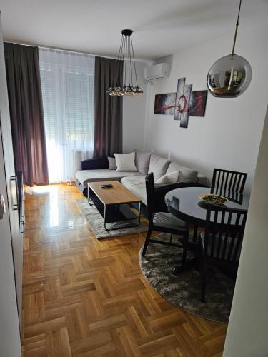 ein Wohnzimmer mit einem Sofa und einem Tisch in der Unterkunft Banjica in Jajinci
