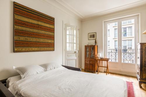 une chambre avec un grand lit et une fenêtre dans l'établissement Veeve - Ambassador Hideaway, à Paris