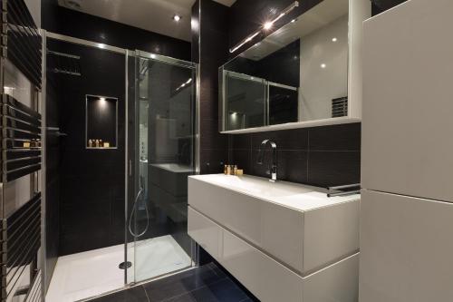 une salle de bain avec un lavabo et une douche dans l'établissement Veeve - Ambassador Hideaway, à Paris