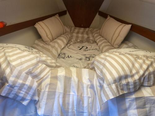 a unmade bed with two pillows on top of it at Séjour unique à bord d un voilier in La Rochelle