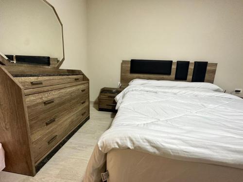 1 dormitorio con 1 cama con tocador y espejo en West Redige ( New Giza ), en Kafr Abū ʼumaydah