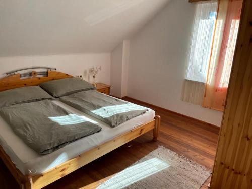 a bedroom with a wooden bed and a window at Ferienhaus Murtal in Weißkirchen in Steiermark