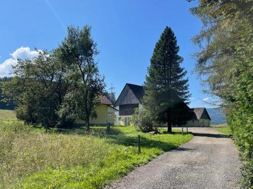 a dirt road leading to a house with trees at Ferienhaus Murtal in Weißkirchen in Steiermark