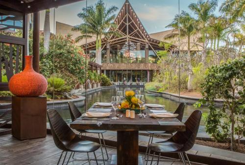 una mesa con sillas frente a un edificio en Lopesan Baobab Resort, en Meloneras