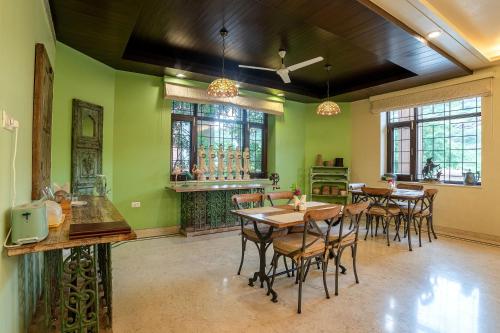 a dining room with green walls and tables and chairs at The Almond Tree in Jodhpur