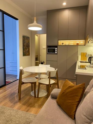 cocina y sala de estar con mesa y sillas en Cozy Urban Retreat en Almaty