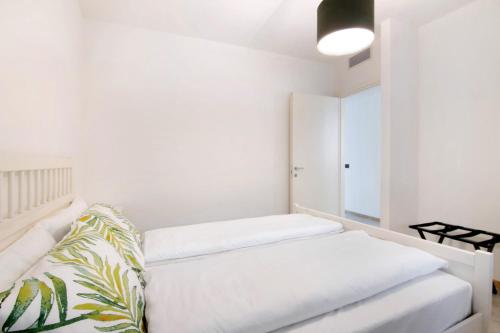 a white room with a bed and a mirror at La villa del lago in giardino in Colico