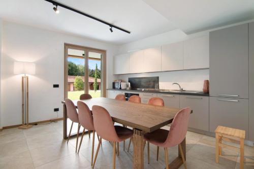 a kitchen with a wooden table and chairs at La villa del lago in giardino in Colico