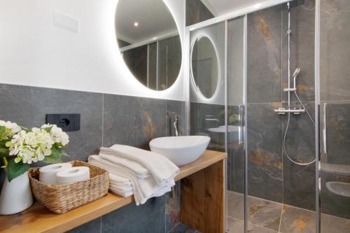La salle de bains est pourvue d'un lavabo et d'une douche. dans l'établissement La villa del lago in giardino, à Colico