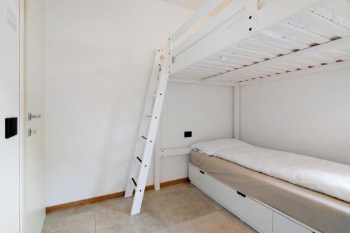 a bedroom with a bunk bed and a ladder at La villa del lago in giardino in Colico
