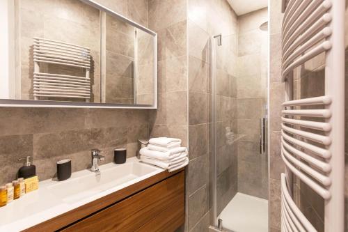 une salle de bain avec un lavabo et une douche dans l'établissement Veeve - Classical Features in the 9th, à Paris