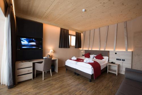 a hotel room with a bed and a desk and a computer at Francesin Active Hotel in Livigno