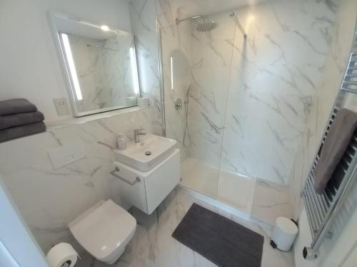 Baño blanco con aseo y lavamanos en Stunning 1-Bed Luxury Studio in Gibraltar, en Gibraltar