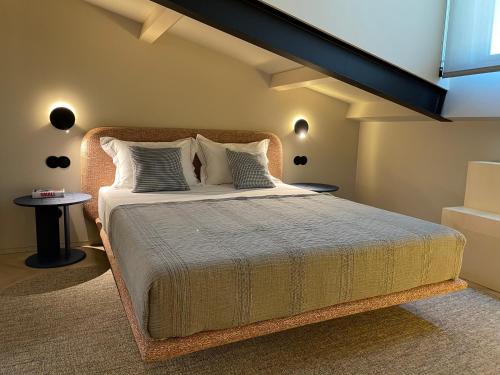 a bedroom with a large bed with white sheets and pillows at SUTRooms in Braga