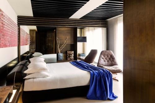 a bedroom with a bed and a desk and chairs at STRAF, Milan, a Member of Design Hotels in Milan