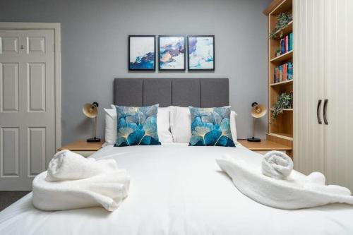 een slaapkamer met een groot wit bed en handdoeken bij Alexandra - WiFi Parking Garden in Walton le Dale