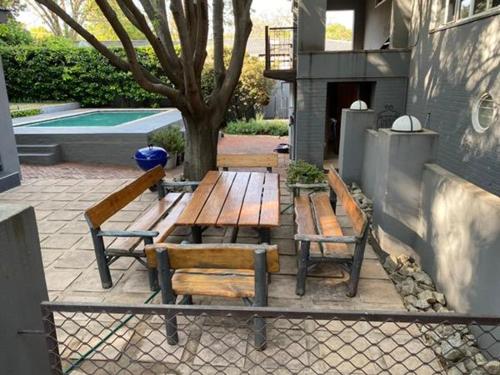 a picnic table and chairs next to a pool at 46 on Allcock Guest Apartment & Luxury Room in Pretoria