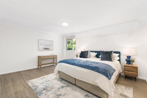 a white bedroom with a large bed and a window at King Bedroom Waterfront Courtyard Apartment in Sylvania