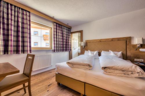 a bedroom with a bed and a desk and a window at Bischoferhaus in Serfaus