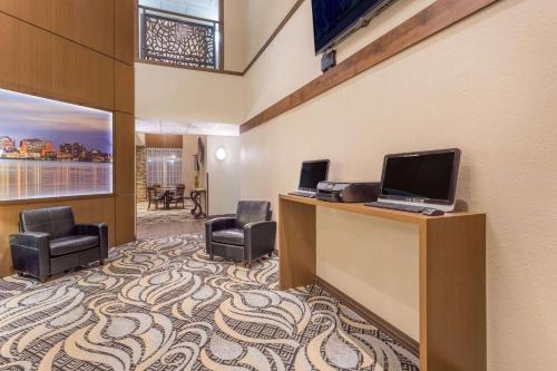 a hotel room with a desk with a computer on it at Wyndham Garden Madison Fitchburg in Madison