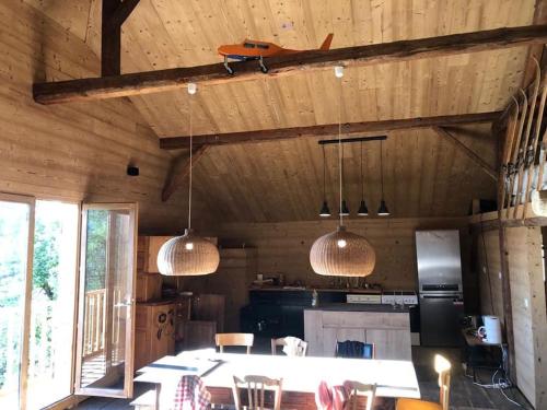eine Küche mit einem Tisch und zwei Hängelampen in der Unterkunft Superbe ferme restaurée de l'Alpage - 200 m2 - 12 pers - SAINT-GERVAIS MONT-BLANC in Saint-Gervais-les-Bains