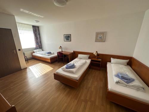 a large room with two beds and a desk at Hotel am Stimbergpark in Oer-Erkenschwick