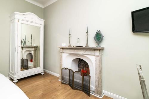 a living room with a fireplace and a mirror at La Piazzetta Rooms & Apartments in Genova