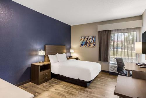 Habitación de hotel con cama blanca y escritorio en MainStay Suites Bourbonnais - Kankakee, en Bourbonnais