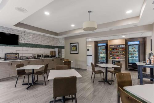 un restaurante con mesas y sillas y una cocina en MainStay Suites Bourbonnais - Kankakee, en Bourbonnais