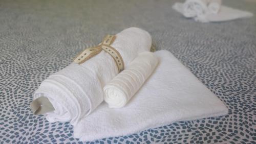 uma pilha de toalhas brancas sentadas numa cama em Green Central house em La Spezia