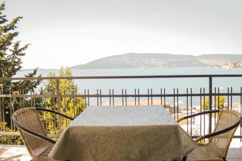 a table and chairs on a balcony with a view of the water at SeaView Zelenika in Herceg-Novi