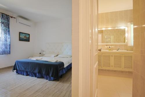 1 dormitorio con 1 cama y baño con lavamanos en Villa Percebe con Piscina Privada, en El Puerto de Santa María