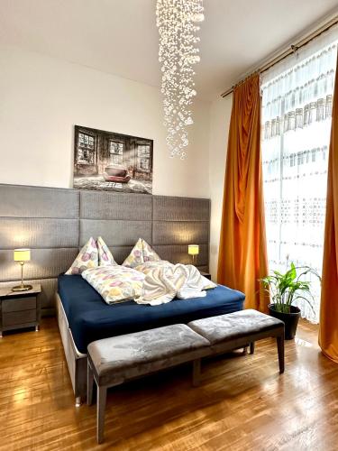 維也納的住宿－Sisi Apartment，一间卧室配有蓝色的床和吊灯。