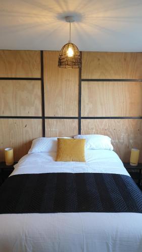 a bedroom with a large white bed with a chandelier at Janitor's Lodge in Ticehurst