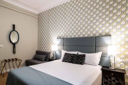 a bedroom with a large white bed and a chair at La Piazzetta Rooms & Apartments in Genova