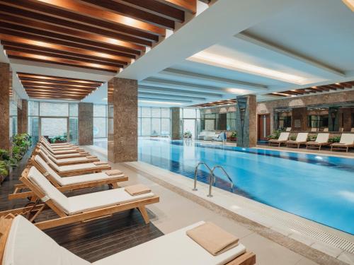 Selectum City Ataşehir في إسطنبول: مسبح الفندق مع كراسي الصالة والمسبح