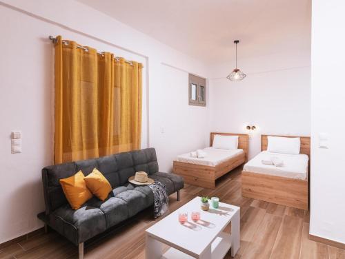ein Wohnzimmer mit einem Sofa und einem Bett in der Unterkunft Sifogiannis Rooms in Kamilari
