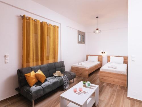a living room with a couch and a bed at Sifogiannis Rooms in Kamilari