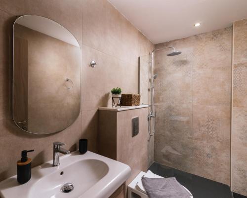 ein Bad mit einem Waschbecken und einer Dusche mit einem Spiegel in der Unterkunft Sifogiannis Rooms in Kamilari