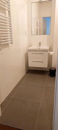 a white bathroom with a sink and a mirror at Cube Apartamenty in Lublin