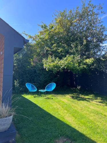 two blue chairs and a table in a yard at Luxury Garden Lodge With Free Parking in Chestfield