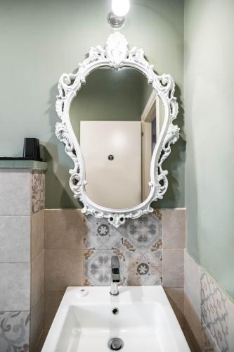 a bathroom with a white mirror and a sink at La Piazzetta Rooms & Apartments in Genova