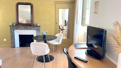 a living room with a television and a table with chairs at Maison Bossoreil - Chambre Layon in Angers