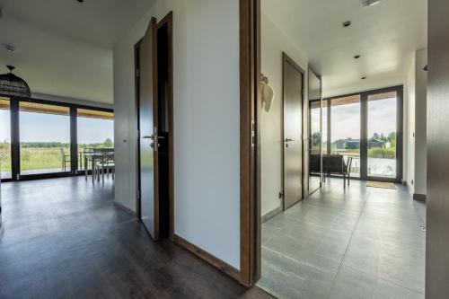 an open hallway with glass doors and a dining room at Lielpīles in Radziņciems