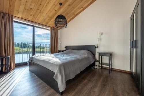 a bedroom with a bed and a large window at Lielpīles in Radziņciems
